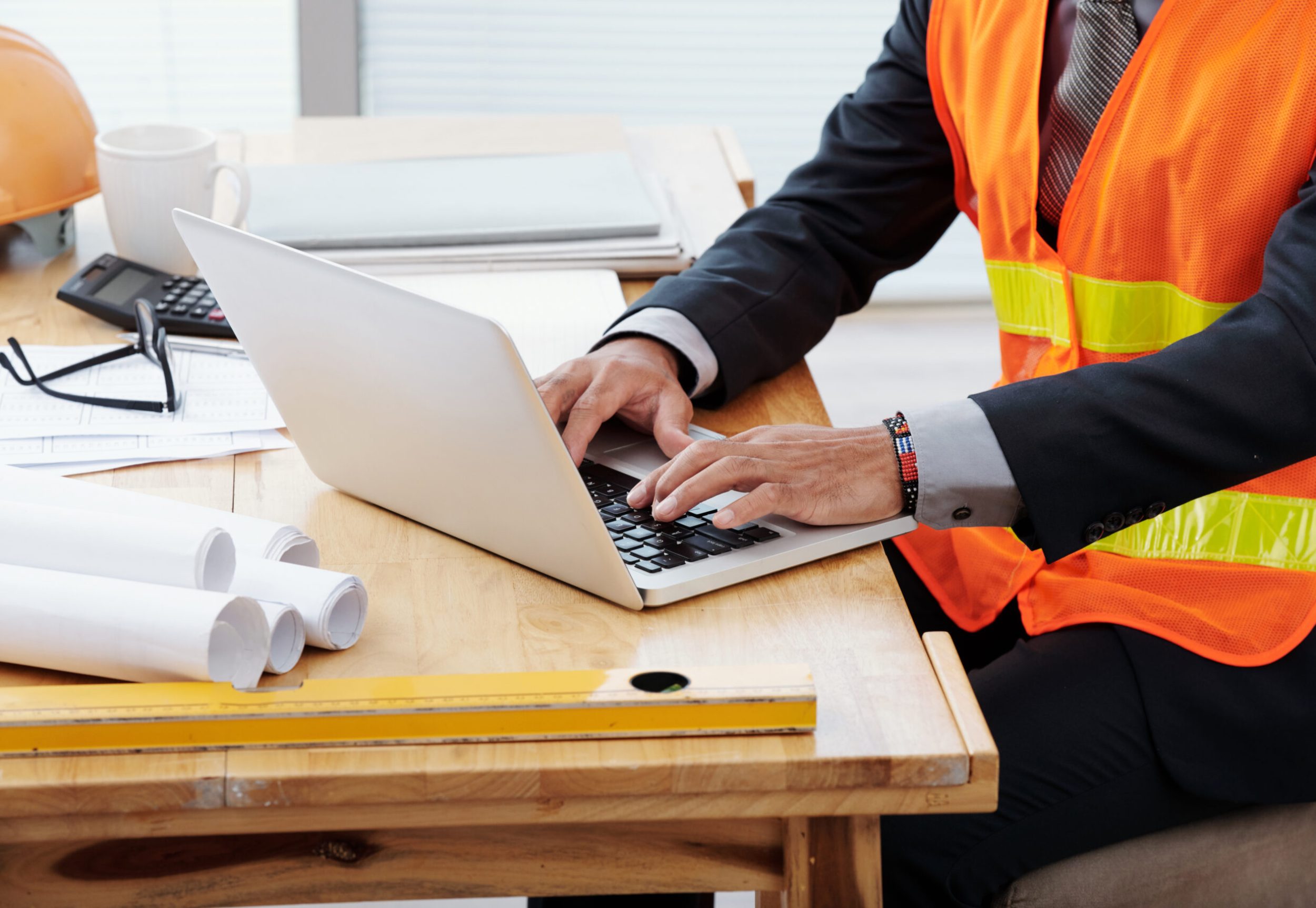 Cropped image of engineer working on laptop in his office